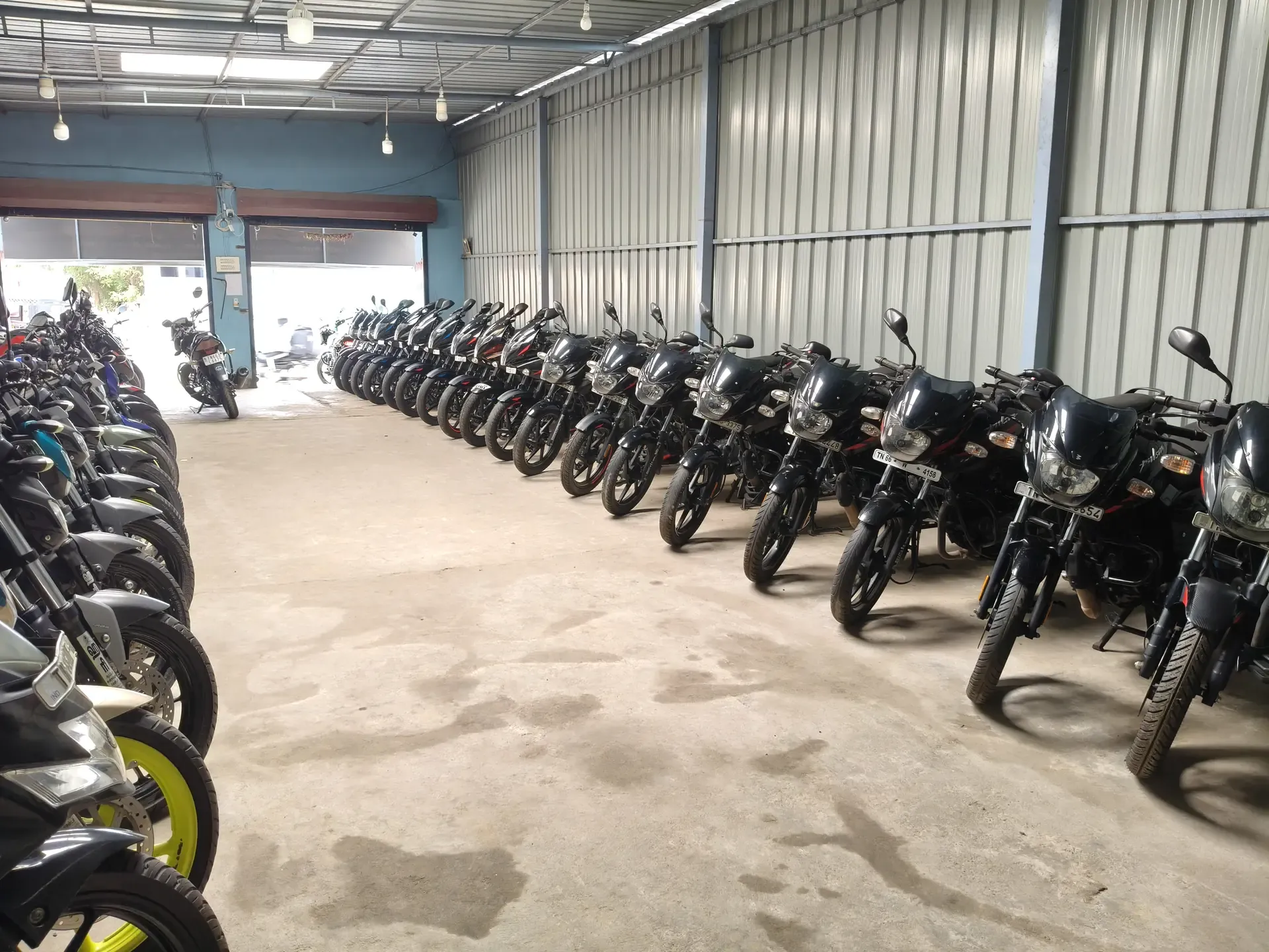 Two long rows of motorcycles in the covered hall