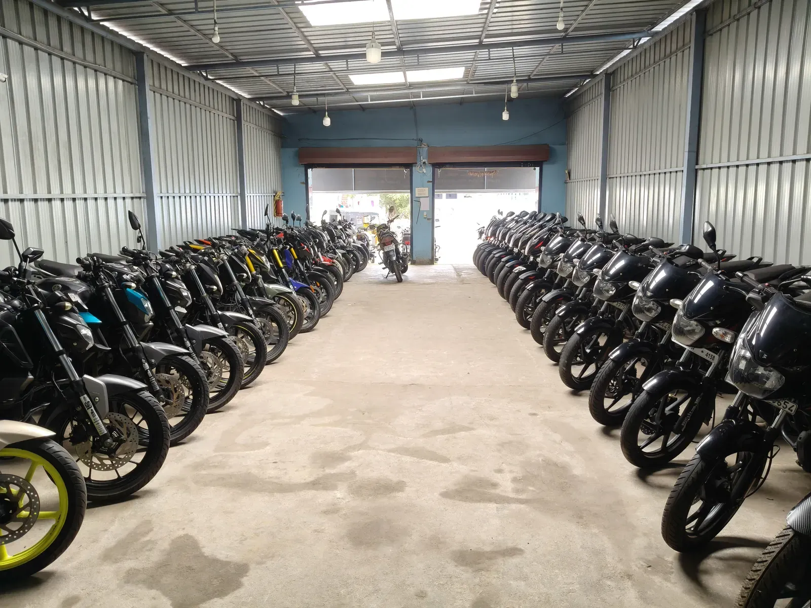 Long aisle of used motorcycles inside the HARI AUTO shed