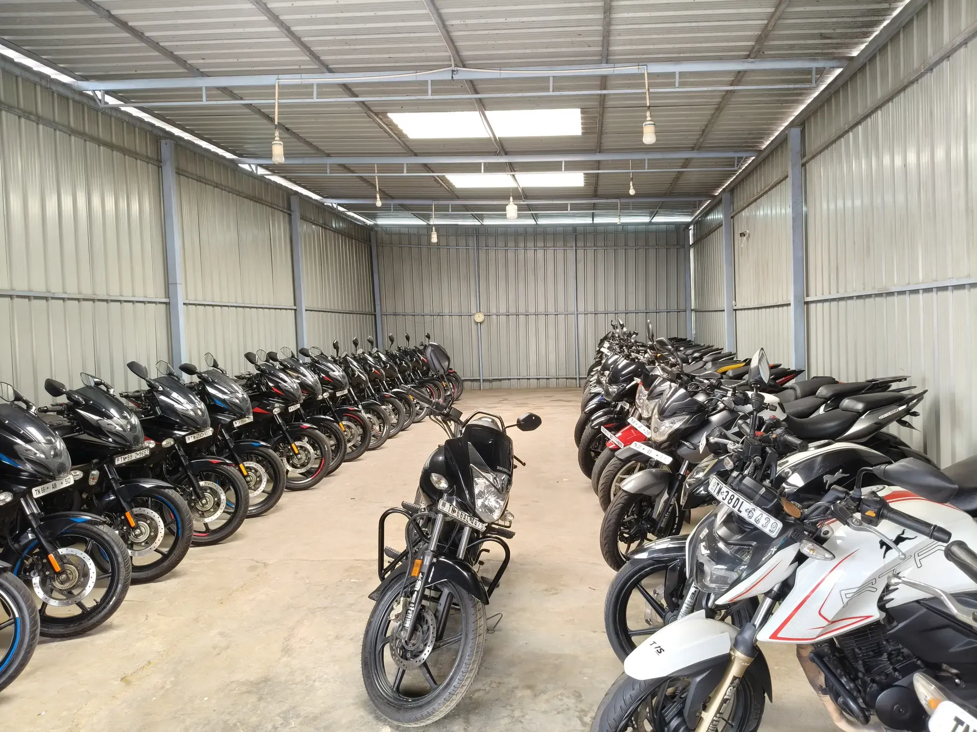 Motorcycles parked in rows in the big shed